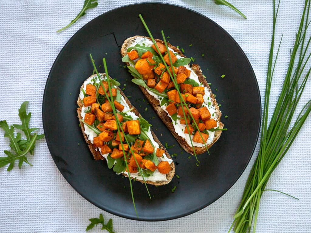 Une recette de tartines au fromage frais, ail et ciboulette avec des petits cubes fondants de patate douce ! Un délice pour l'apéro. Recette végétarienne.