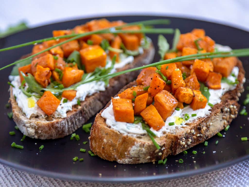 Une recette de tartines au fromage frais, ail et ciboulette avec des petits cubes fondants de patate douce ! Un délice pour l'apéro. Recette végétarienne.