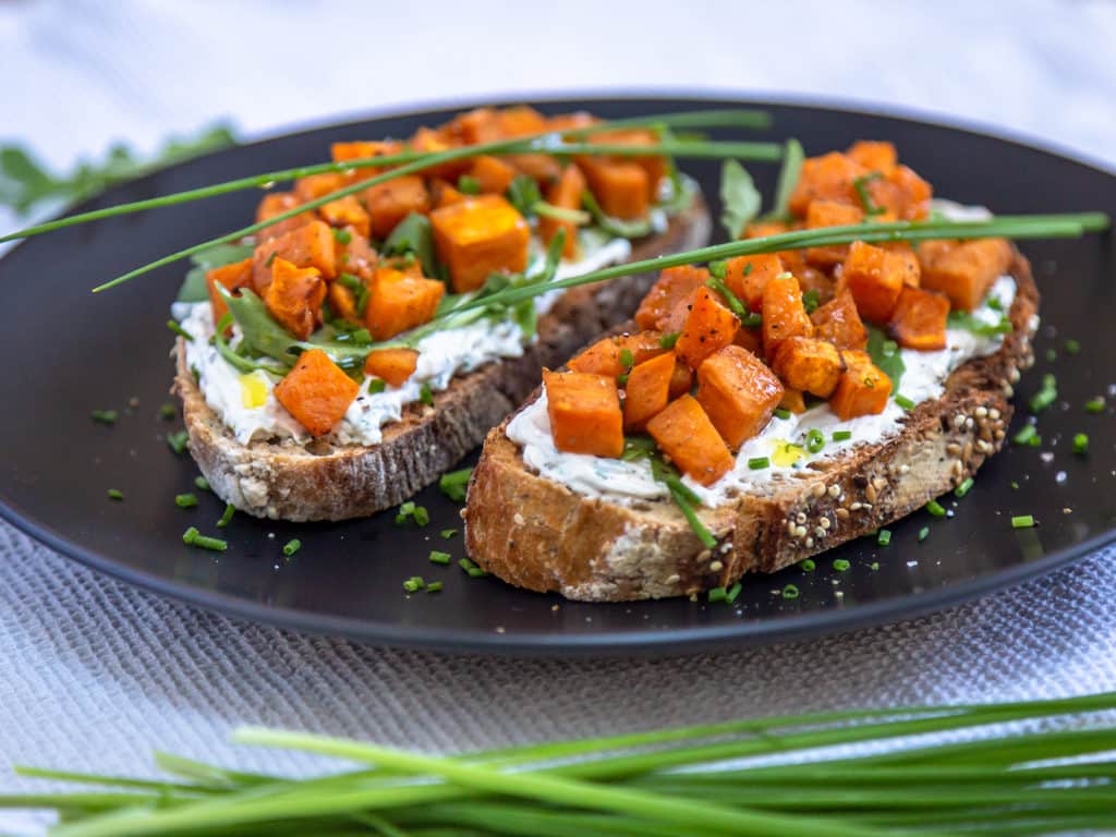 Une recette de tartines au fromage frais, ail et ciboulette avec des petits cubes fondants de patate douce ! Un délice pour l'apéro. Recette végétarienne.