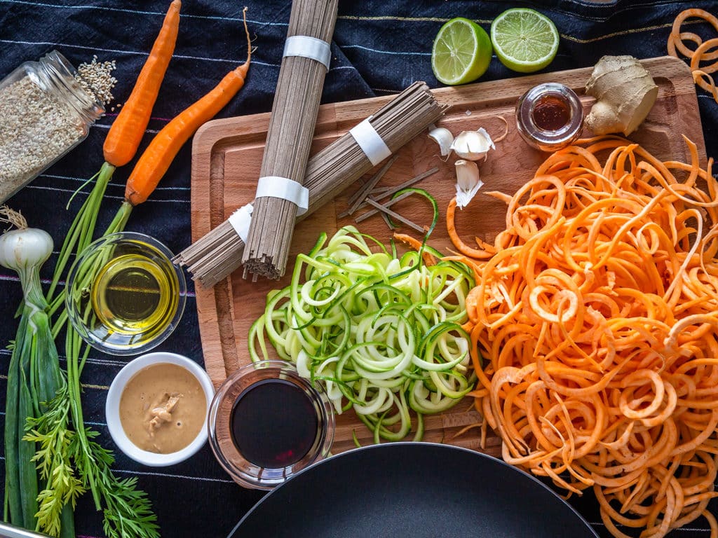 Un wok de nouilles de légumes sautées, avec une sauce gingembre, cacahuète et citron vert ! Recette vegan et adaptable sans gluten.