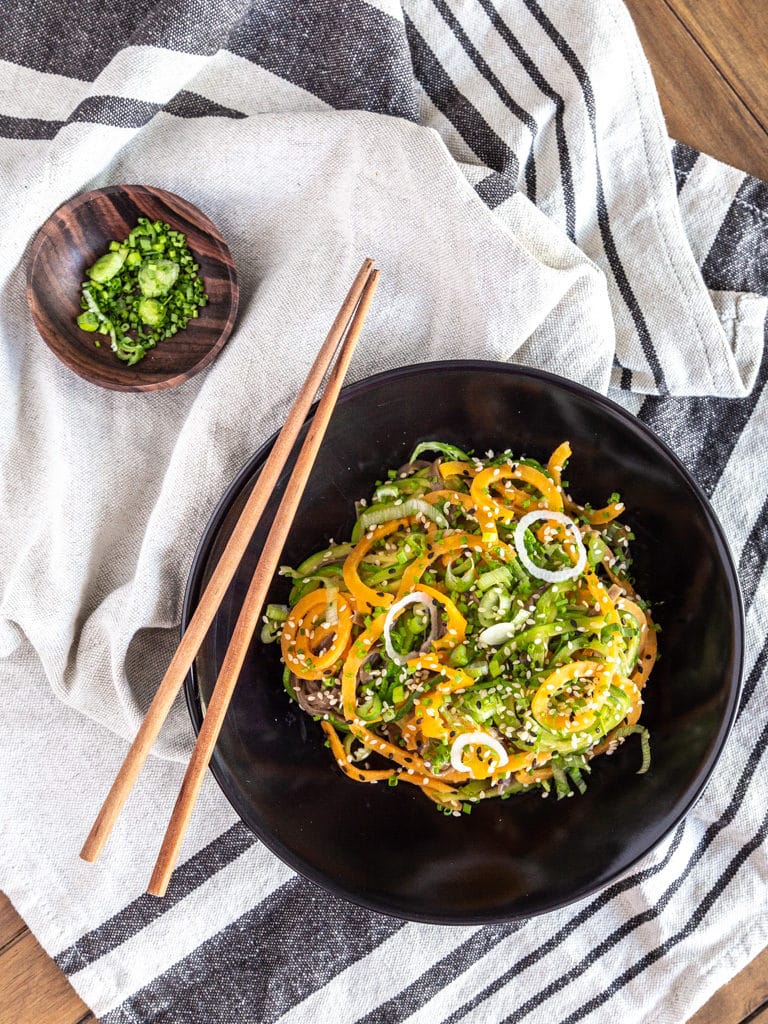 Un wok de nouilles de légumes sautées, avec une sauce gingembre, cacahuète et citron vert ! Recette vegan et adaptable sans gluten.