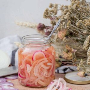 Oignons Doux Vinaigrés (Vegan, Sans Gluten) Une recette super simple et super rapide qui vous permettra de sublimer vos salades, sandwichs, tacos et tout autre préparation, ça vous dit ? Je vous propose de découvrir cette recette d’oignons vinaigrés. Vous vous rappelez de la recette de petits légumes au vinaigre ? Je suis partie de la même base, mais comme je voulais une préparation plus douce, j’ai mis un peu moins de vinaigre blanc, et j’ai ajouté du vinaigre de cidre, que je trouve plus parfumé et moins fort ! Bon, et j’ai mis du sirop d’érable, plutôt que du sucre, parce que … j’aime le sirop d’érable ..; Faut-il une autre raison ? En tout cas, ces petits oignons se marient parfaitement dans une salade de saison (quinoa, cranberries ou lentilles et carottes rôties par exemple) ou dans des petits tacos végé :) Prep : 5min 120g d’oignon doux (blanc ou rouge) (soit un bel oignon) 120ml d’eau 60ml de vinaigre d’alcool 60ml de vinaigre de cidre 2 c-à-c de sirop d’érable 1,5 c-à-c de sel Emincer les oignons en lamelles (plus ou moins suivant que vous les aimiez plutôt tendres ou croquants). Les mettre dans un bocal de 300ml. Dans une casserole, porter à ébullition tous les autres ingrédients. Éteindre le feu dès que le mélange commence à bouillir et verser immédiatement dans le pot. Laisser refroidir avant de fermer le pot. Vous pouvez les manger très rapidement (après une demi-heure de repos), ou les conserver 4-5 jours au frigo.
