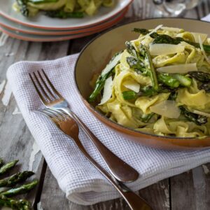 Tagliatelles à la Crème d’Asperges Citronnée (avec option végane) La saison des asperges commence et je dois bien dire que je suis ravie ! J’adore ça ! Je les aime à toutes les sauces ! Autant cuites simplement à la vapeur avec de la vinaigrette ou en risotto (comme ici) ou en sauce crémeuse pour les pâtes comme la recette d’aujourd’hui ! J’ai un petit faible pour les asperges vertes, dont j'apprécie particulièrement la consistance plus ferme que les asperges blanches (même si j’adore les blanches aussi !) Enfin, ici, elles sont préparées en sauce bien crémeuse pour accompagner des tagliatelles fraîches que vous pouvez même faire maison si vous avez le temps ! La recette est vraiment simple et ne demande pas beaucoup d’ingrédients ! Un peu de citron, d’ail, de crème et de parmesan ! En plus, c’est très simple de la “veganiser” en utilisant de la crème végétale et du parmesan végétal (recette ici pour les curieux). Autre avantage de cette recette : ne salir d’une poêle et une casserole, alors je ne sais pas pur vous, mais perso, faire la vaisselle… me gave, et donc je suis plutôt contente quand j’arrive à la limiter ! temps de prep 30min temps de cuisson 25min pour 4 personnes 500g d’asperges vertes (une botte) 1 pincée de gros sel jus d’½ citron 150ml de crème (végétale ou animale, soja pour nous) 30g de parmesan végétal ou véritable 2 c-à-s d’huile d’olive 2 gousses d’ail pressées sel, poivre 500g de tagliatelles fraîches Faites bouillir un grand volume d’eau avec une belle pincée de gros sel. Commencez par préparer vos asperges : rincez les puis couper la tige dure des asperges (environ 4-5cm). Ensuite, coupez les pointes des asperges (environ 4cm), et détailler la tige restante en tronçons d’un cm environ. Réservez les pointes. Mettez les tronçons à cuire dans l’eau bouillante, jusqu’à ce qu’ils soient bien tendres (environ 10-15min). Puis égouttez-les. Mixez le jus de citron, la crème, le parmesan et les tronçons pour obtenir une sauce bien crémeuse. Ajustez l'assaisonnement (sel, poivre). Réserver. Remettre de l’eau à bouillir dans votre casserole, on l’utilisera pour cuire les tagliatelles. Faire chauffer l’huile d’olive dans une grande poêle, à feu moyen-fort. Faire revenir rapidement l’ail pressé, puis ajouter les pointes d’asperges et faites les revenir une bonne dizaine de minutes, jusqu’à ce qu’elles commencent à être tendres, mais toujours un peu croquantes ! Dans cette même poêle, verser la crème d’asperge et faites la chauffer à feu moyen pour la faire légèrement réduire et surtout récupérer les petits morceaux d’ail restants ! Ca va délicieusement relever le goût de votre crème ! Mettez les tagliatelles à cuire dans l’eau bouillante et égouttez les rapidement (c’est bien s’il reste un peu d’eau de cuisson). Versez-les dans la poêle avec la crème et les pointes, mélanger et servir chaud !