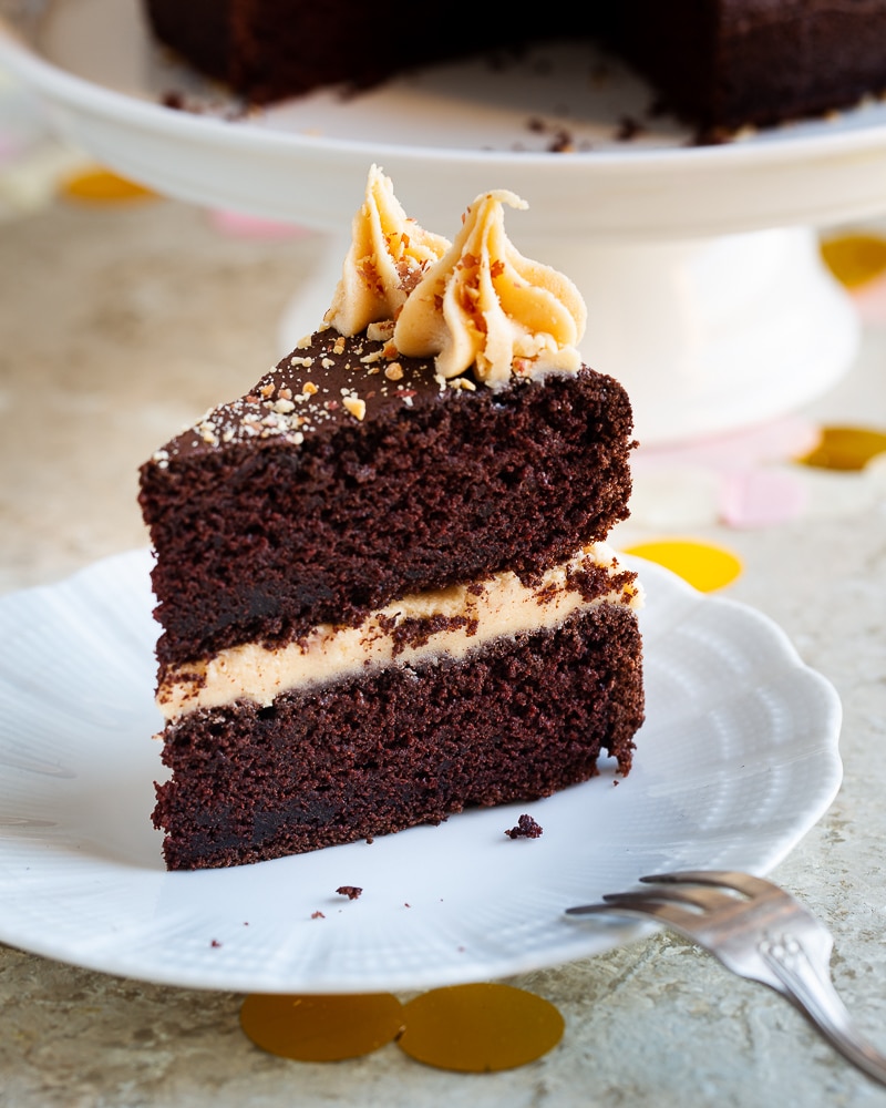Un layer cake chocolat et sa crème au beurre de cacahuète. BOUM ! Laissez-vous tenter par une part de ce gâteau décadent associant la gourmandise du chocolat et la douceur d’une crème au beurre de cacahuète. Un véritable délice !