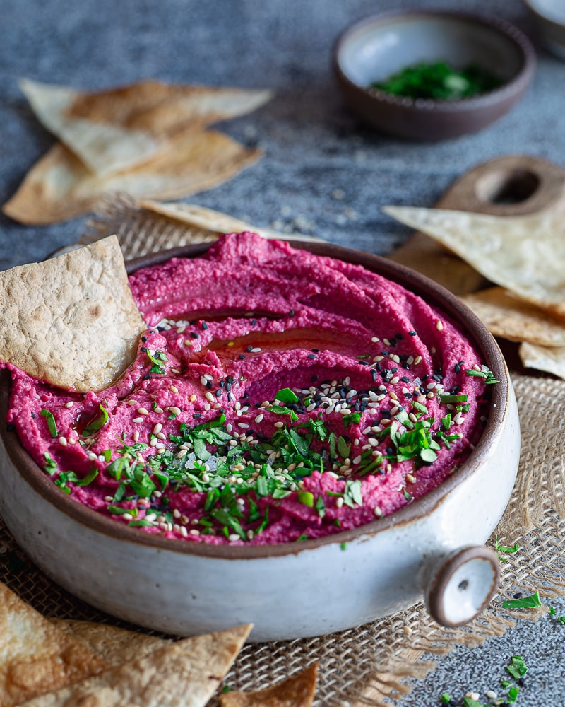 Un houmous à la betterave d'un rose éclatant, légèrement sucré et délicieusement sain, très facile à réaliser en plaçant tous les ingrédients dans le bol d'un mixeur.