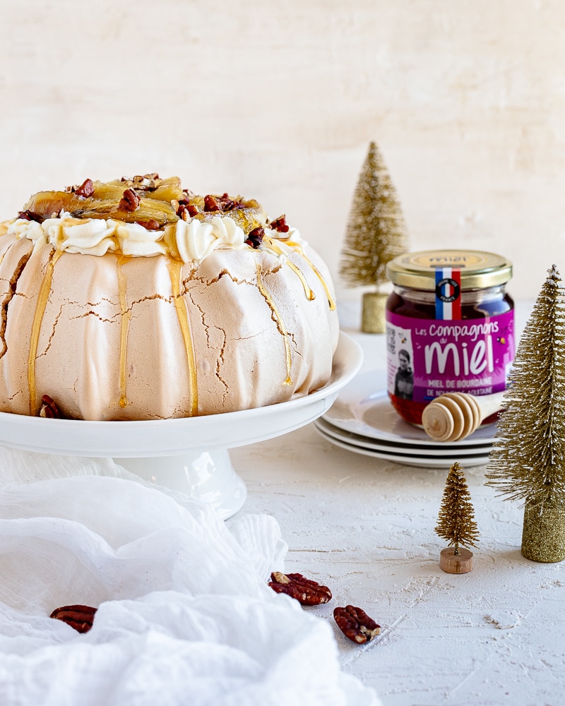 Une Pavlova Bananes Flambées gourmande à souhait et idéale comme dessert de Noël. Une meringue croquante à l'extérieur et comme un marshmallow à l'intérieur, le tout surmontée d'une chantilly au miel de Bourdaine et d'une pluie de noix de pécan !