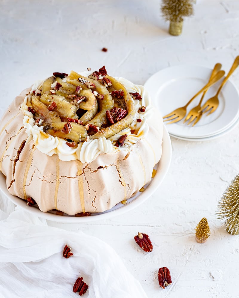 Une Pavlova Bananes Flambées gourmande à souhait et idéale comme dessert de Noël. Une meringue croquante à l'extérieur et comme un marshmallow à l'intérieur, le tout surmontée d'une chantilly au miel de Bourdaine et d'une pluie de noix de pécan !