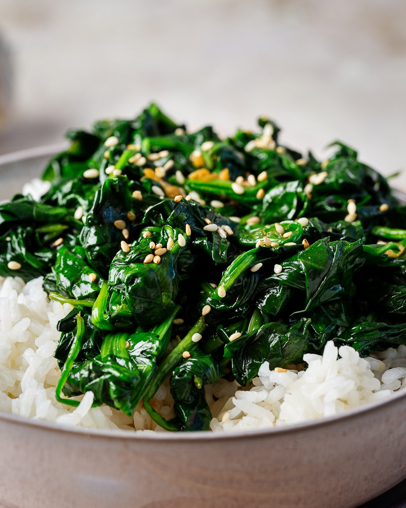 Recette express d’épinards sautés à la sauce soja et au sésame. Parfaite avec du riz et un œuf au plat. Simple, rapide et pleine de goût.