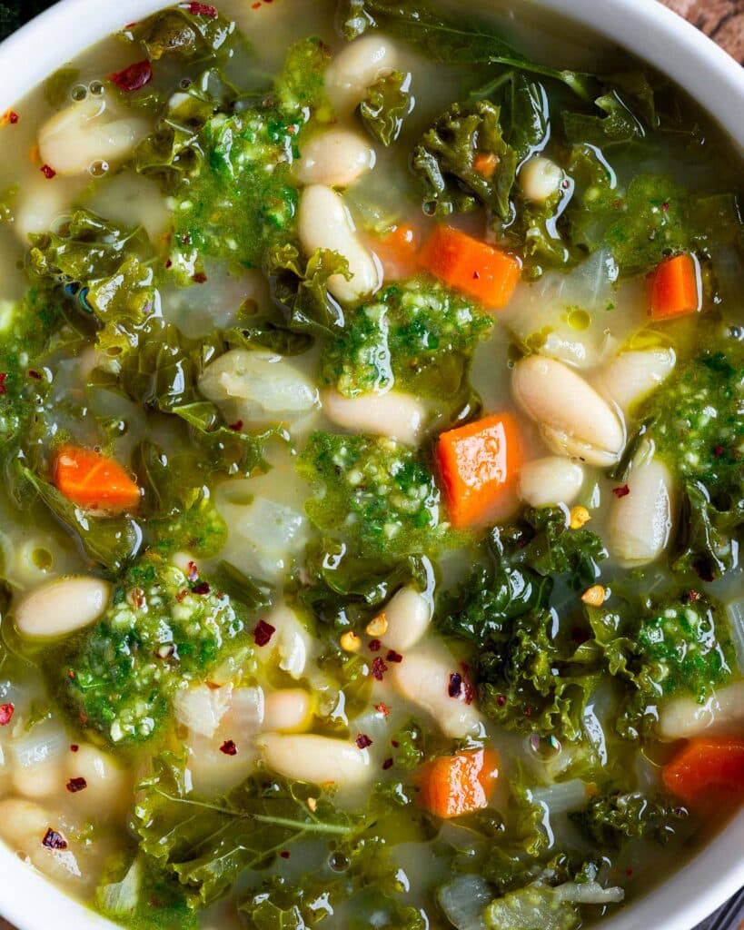 Soupe crémeuse aux haricots blancs et kale, vegan, nourrissante et riche en protéines. À servir avec une picada noix kale pour plus de caractère.