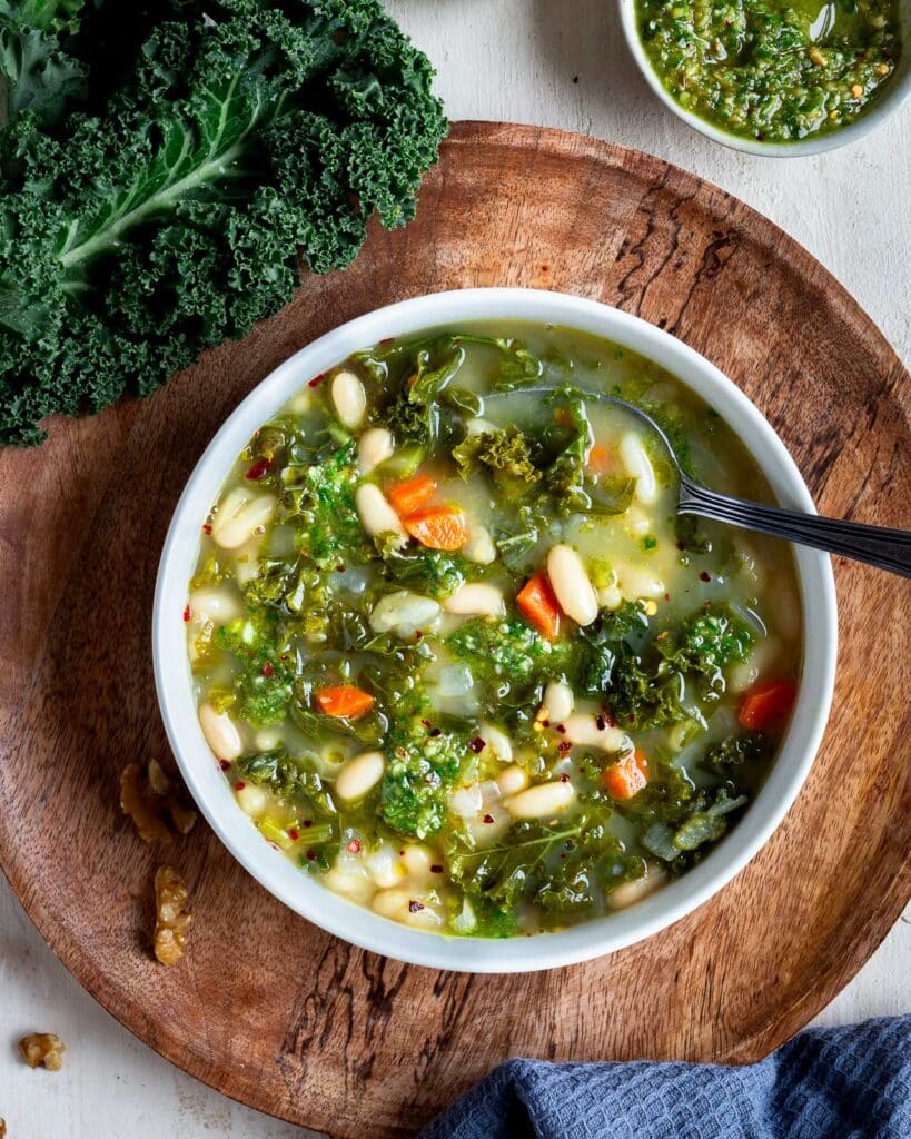 Soupe crémeuse aux haricots blancs et kale, vegan, nourrissante et riche en protéines. À servir avec une picada noix kale pour plus de caractère.